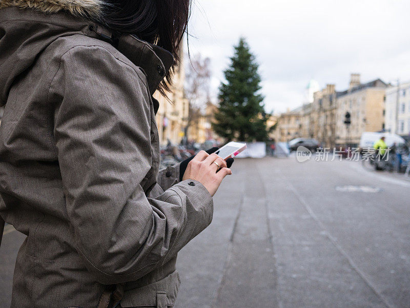 女人在街上用手机发短信