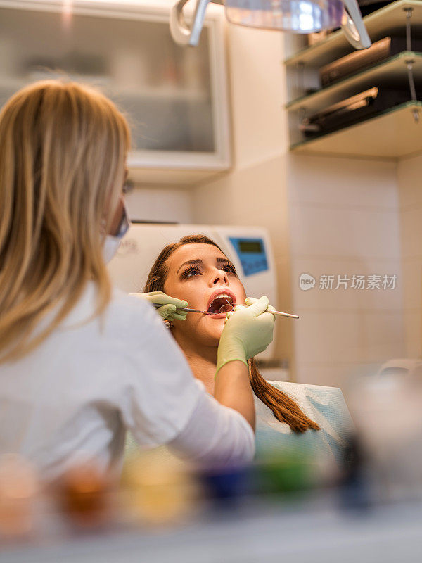年轻女子在牙科诊所接受体检。