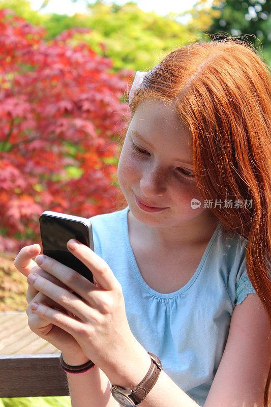 一个女孩在用手机，说话，笑，看，花园
