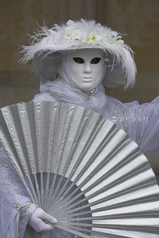 白色女性面具与银色服装在威尼斯狂欢节