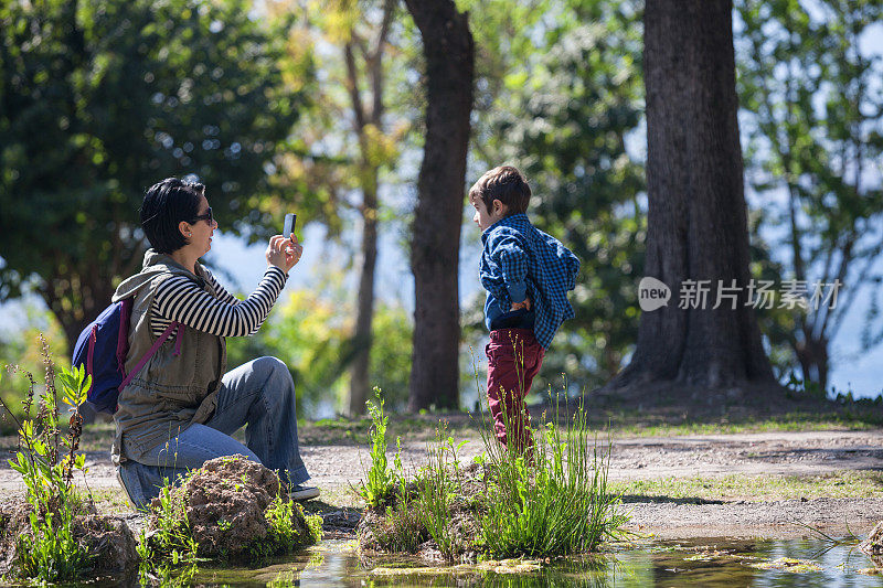 千禧妈妈在户外给儿子拍照