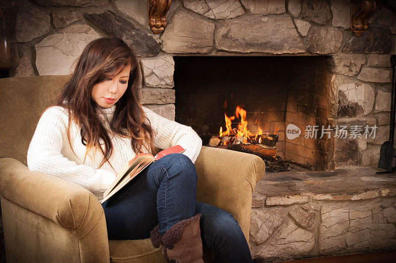 漂亮女人在熊熊炉火旁看书