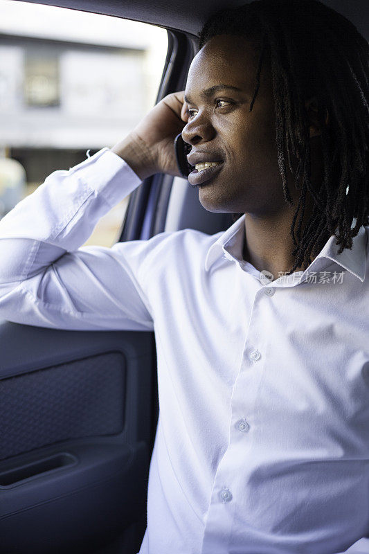 非洲商人坐在车里讲电话