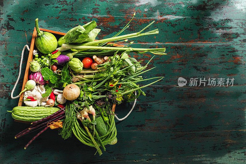 传统的新鲜泰国蔬菜，香草和香料装在旧箱子里。