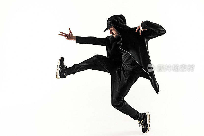 一个嘻哈男霹雳舞舞者的剪影在白色的背景上跳舞