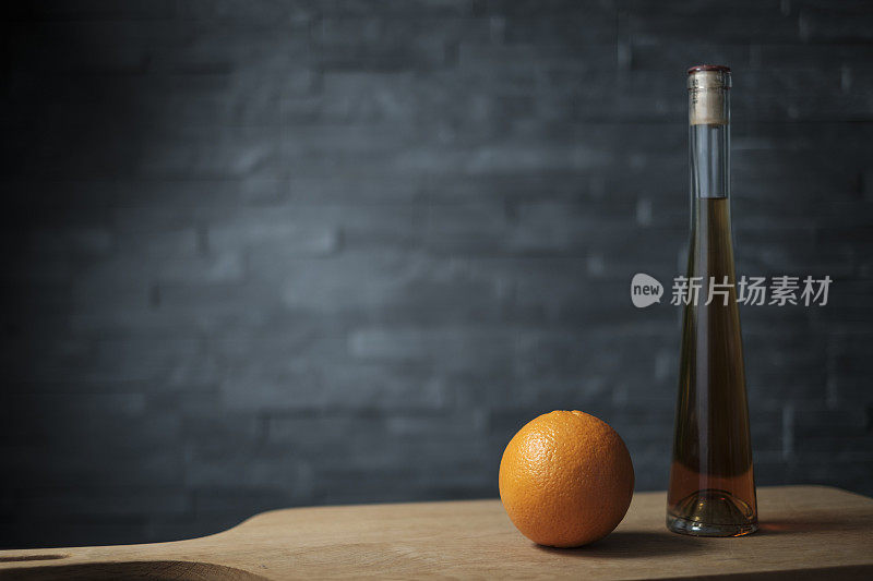 橘子和一瓶酒放在一块木板上
