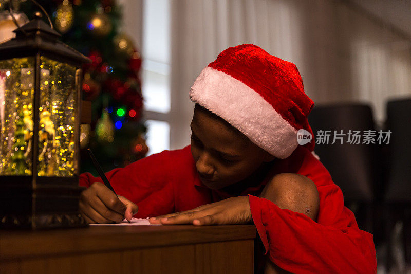 拉丁裔男孩在家里给圣诞老人写圣诞信