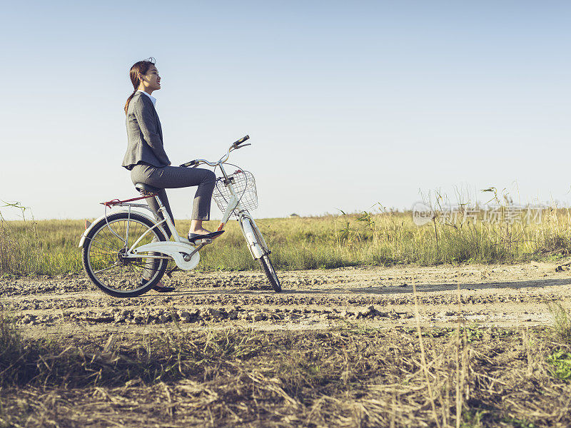 一个年轻的女商人坐在乡下的bicyale上的肖像