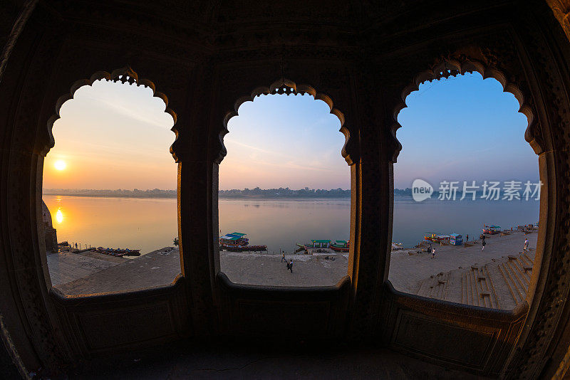 从印度中央邦Maheshwar的宏伟宫殿透过拱门望去。日出时的高铁和神圣的纳恩马达河。