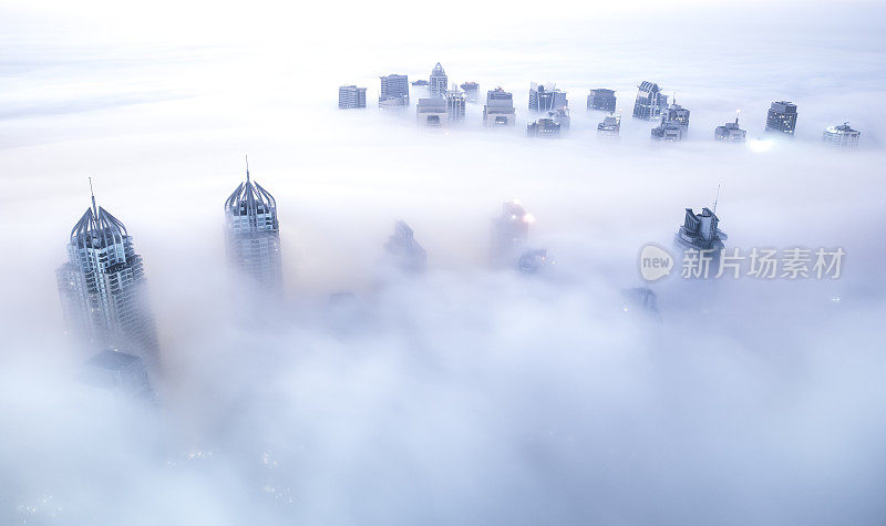 在冬天的早晨，摩天大楼被浓雾包围着。