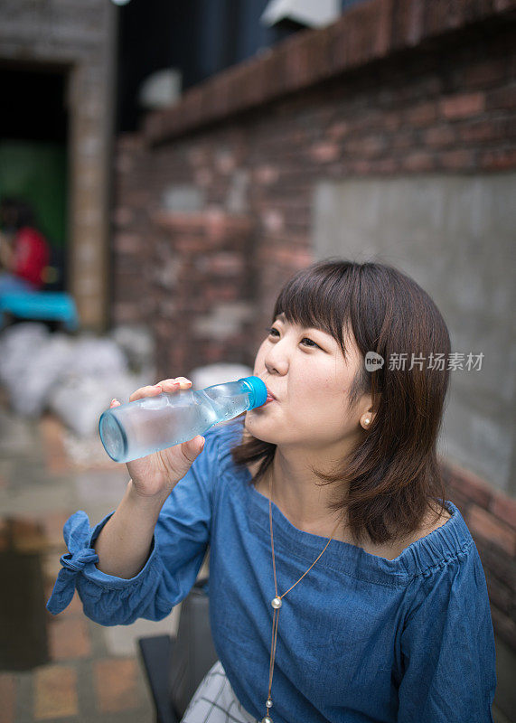 在老城区喝苏打水的年轻女人