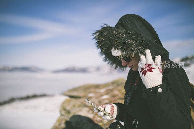 女孩在户外的山峰上发短信。