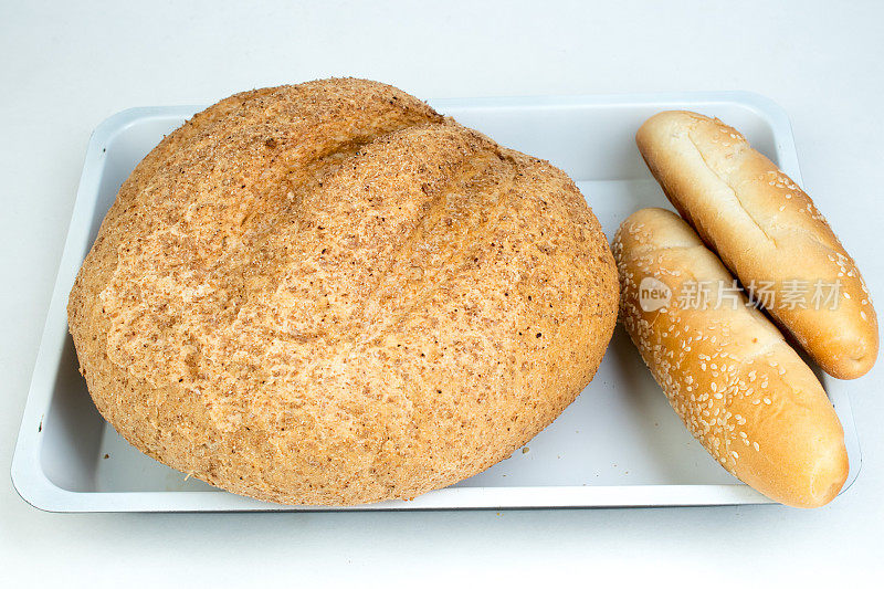 木桌的背景上放着许多混合面包和烤面包卷