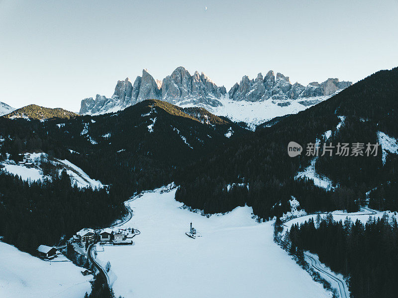 鸟瞰冬天多雪的白云石山峰和小教堂