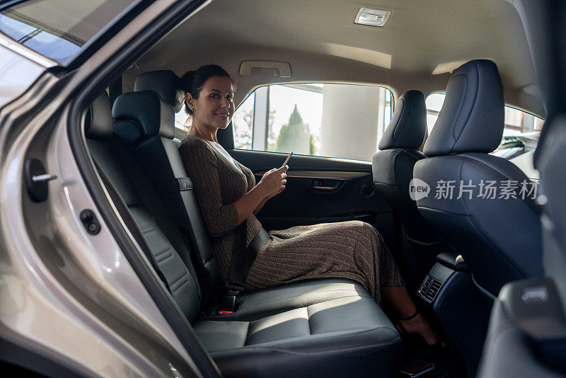 一个女人在车上用手机