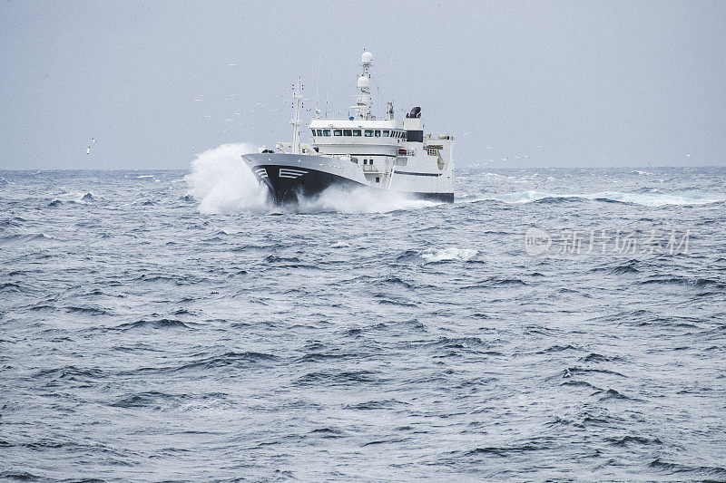 在波涛汹涌的海面上出海的拖网渔船