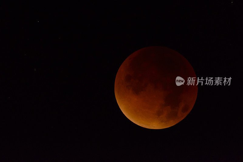 黑暗夜空中的月全食。地球挡住了太阳光使月亮变红了