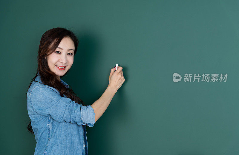 微笑的女人在黑板上写字