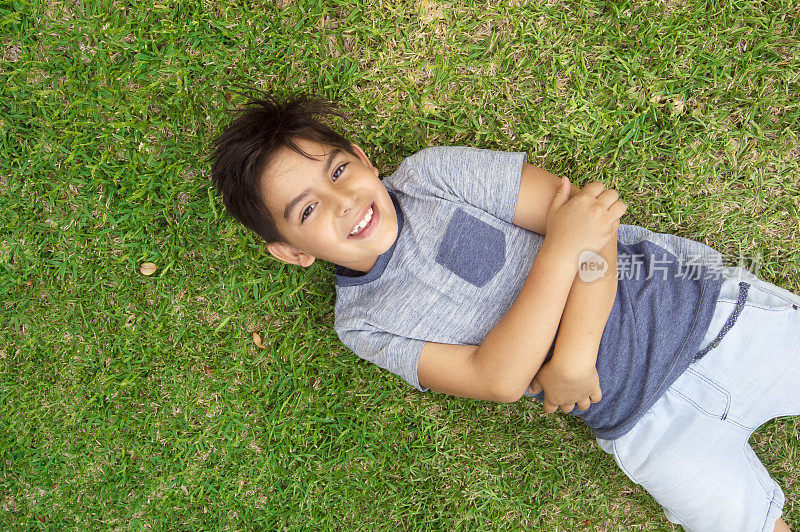 年轻的混血男孩躺在草地上