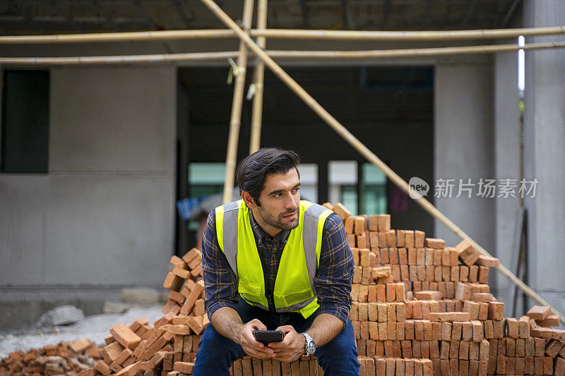 蓝领工人在建筑工地与同事一起工作。