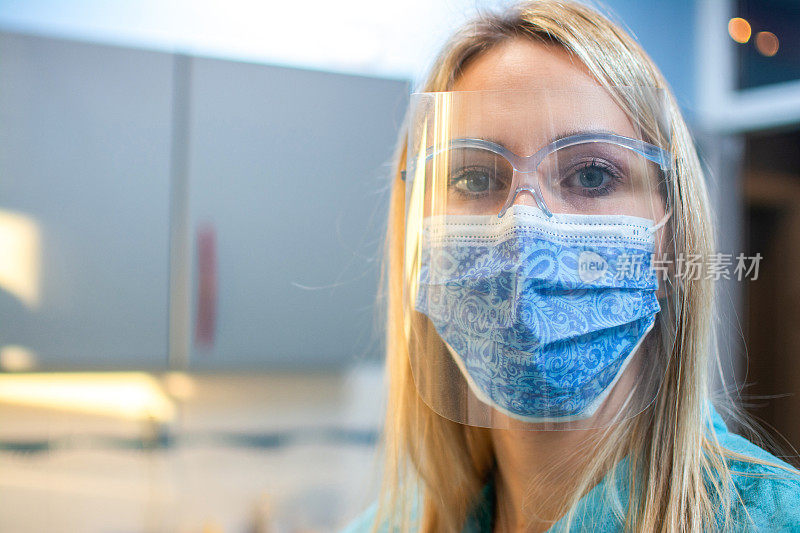 年轻女护士戴着防护面罩在办公室的特写。