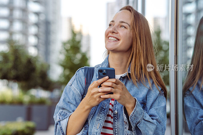 年轻女子一边走路一边用智能手机