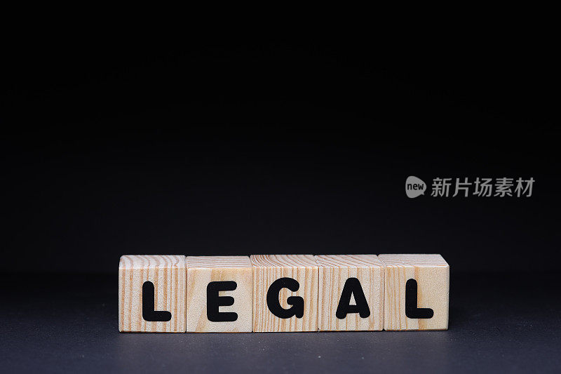 黑色背景上木制方块上的法律字
