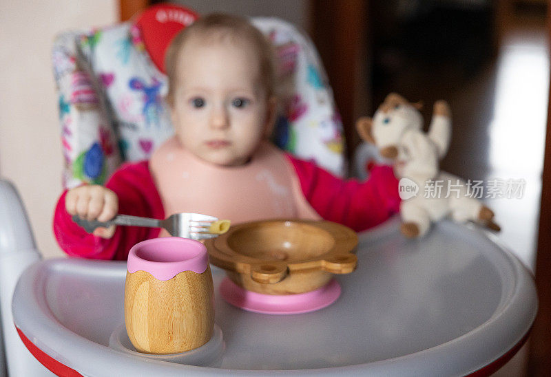 婴儿吃的是儿童用的木制餐具。