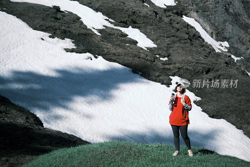 女徒步旅行者正在山里喝水