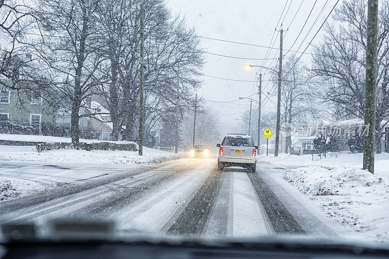 冬季暴风雪村庄街道上的暴风雪汽车交通