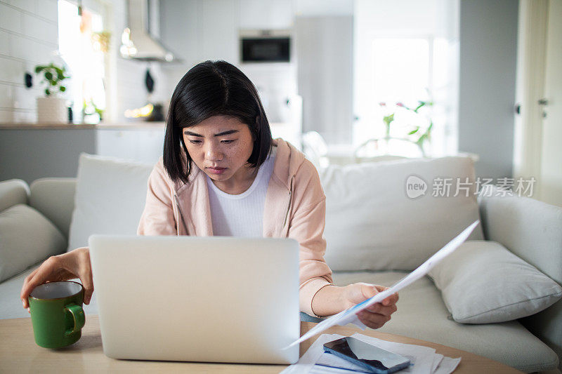 年轻女子在家里清点账单