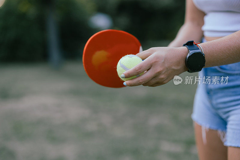 一名女子在大自然中玩匹克球比赛的照片。
