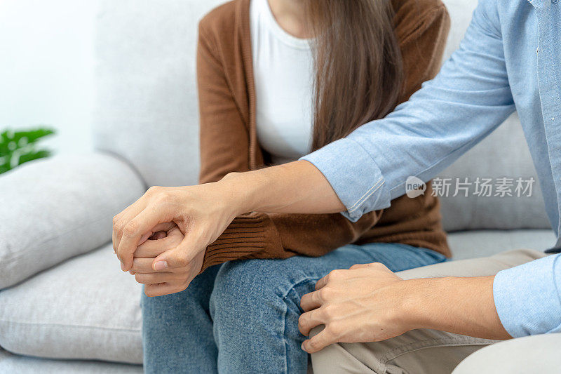 夫妻在与精神科医生讨论家庭问题时，手牵着手互相支持。丈夫鼓励妻子患抑郁症。心理，挽救离婚;携手共进，信任，关怀