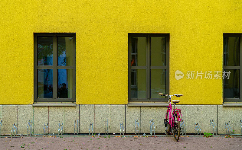 停放在黄色建筑物前的自行车后视图