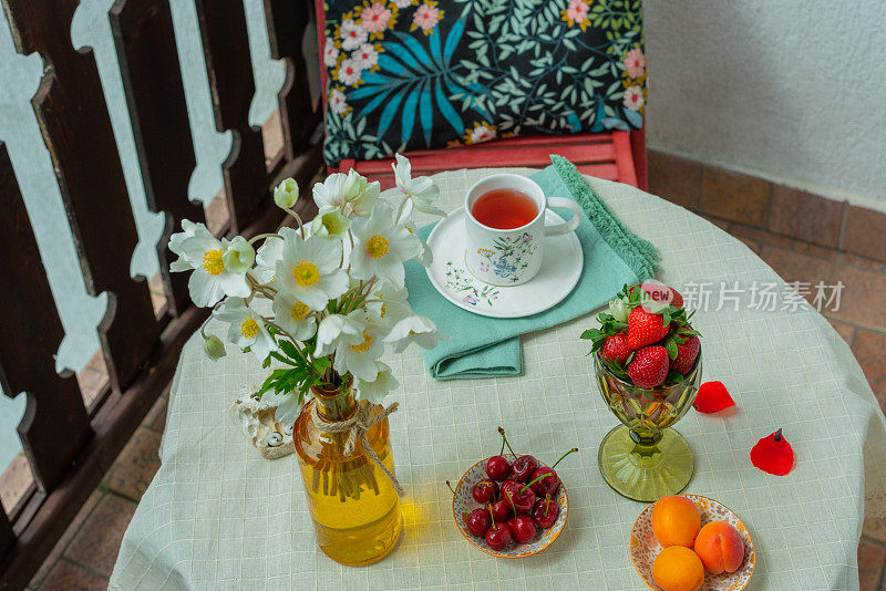 在乡间别墅的露台上喝着鲜花和水果的早茶。平躺