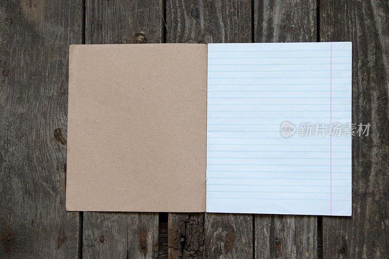 空白打开的笔记本在一把尺子上躺在木桌上，留出文字空间