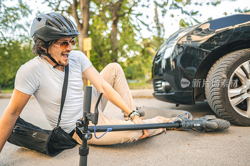 戴着防护头盔的男子在骑电动摩托车事故后膝盖疼痛
