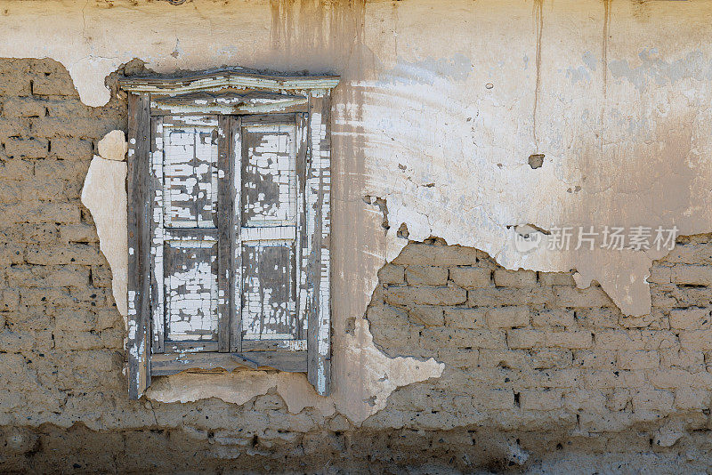 旧土坯房的墙，破旧的木窗，剥落的灰泥