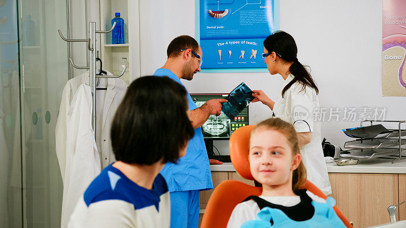 一组口腔医生正在分析小病人的牙齿x光片