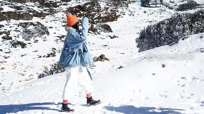 一个女人在寒冷的天气里穿行于白雪覆盖的山林之中