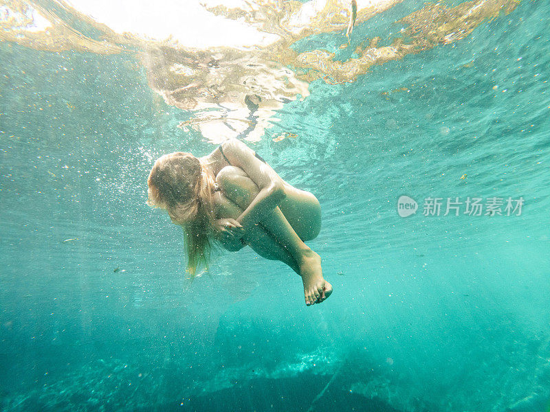 女人漂浮在水下，放手