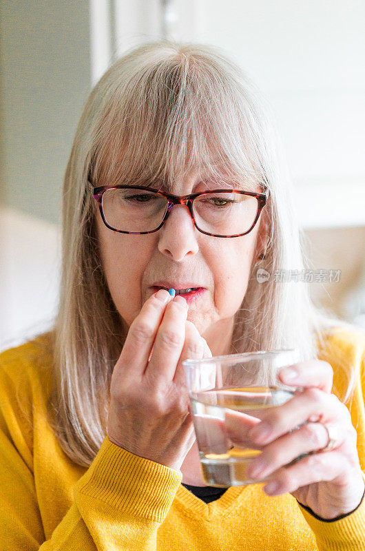 一位老年妇女正在服用药物