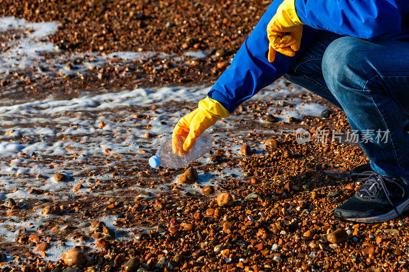 中年男子正在清理海滩上的塑料污染