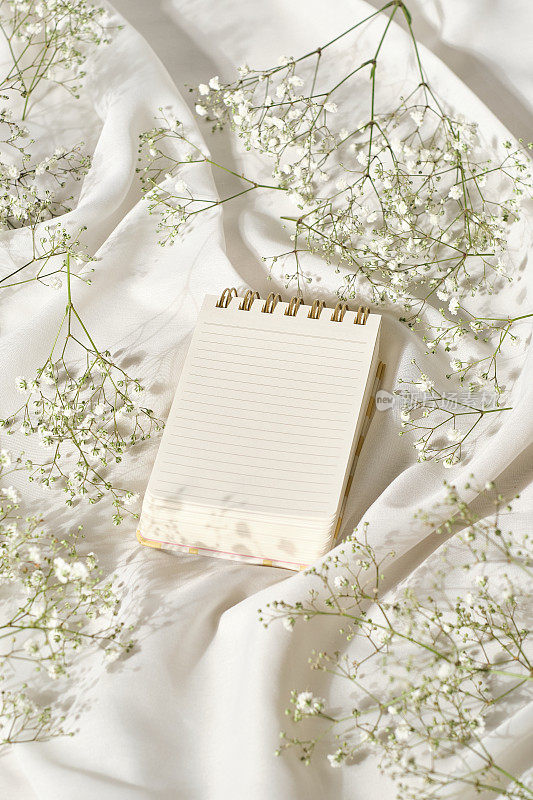 小口袋笔记本上的丝绸布与鲜花