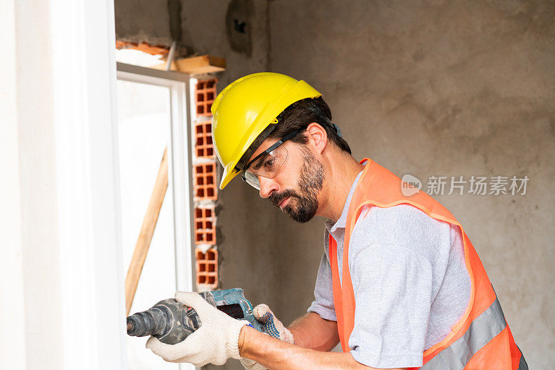 在工地上用钻机工作的建筑工人