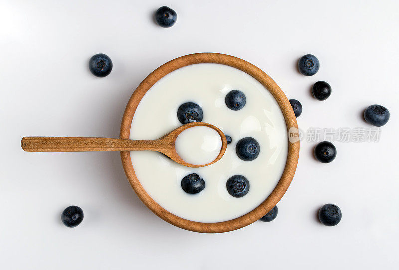天然木碗里的白酸奶和蓝莓。