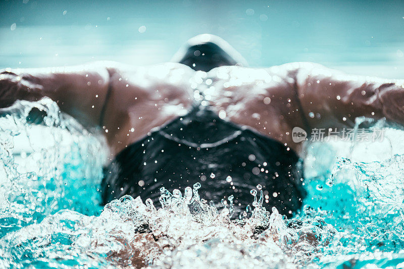 蝶泳运动员的背部。关注水波纹