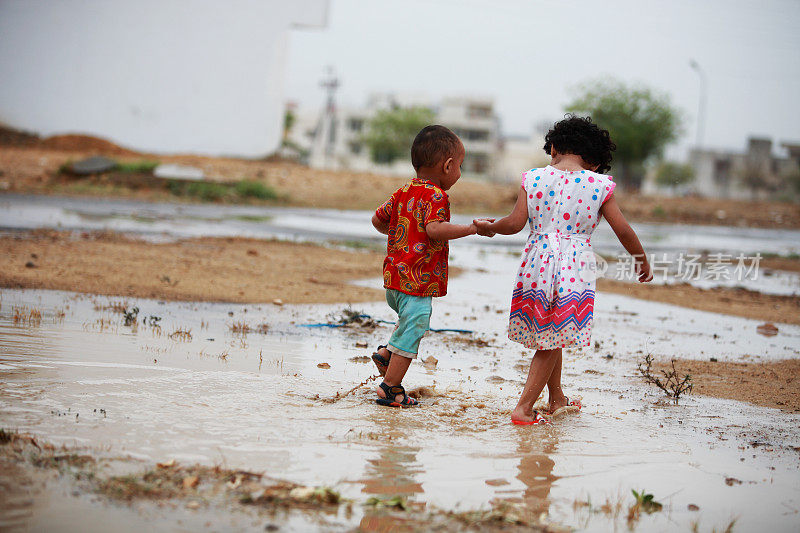 孩子兄弟姐妹爱玩自由雨水水坑