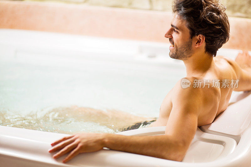 在热水浴缸里放松的男人。