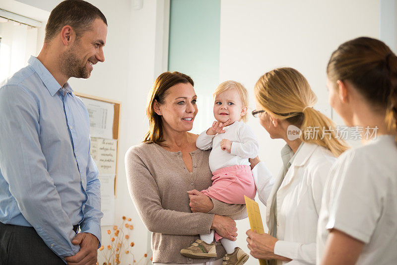 儿科医生与婴儿和她的家人